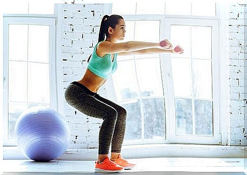 Kneeling to tone the legs with dumbbells